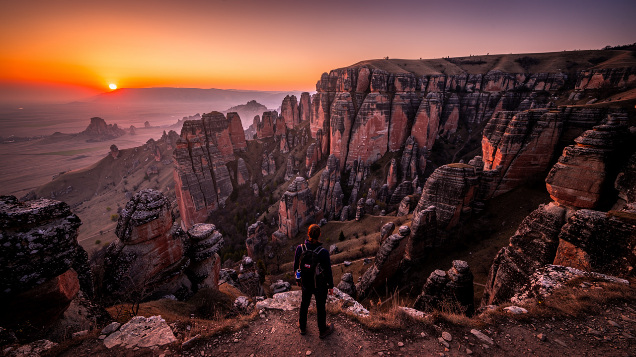 Silhouette of a tourist watching the sunset over the Belogradchik Rocks.